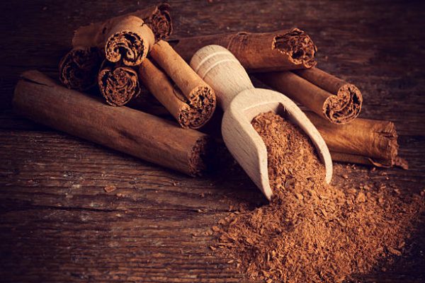 Sticks and ground ceylon cinnamon with wood spoon on wooden table